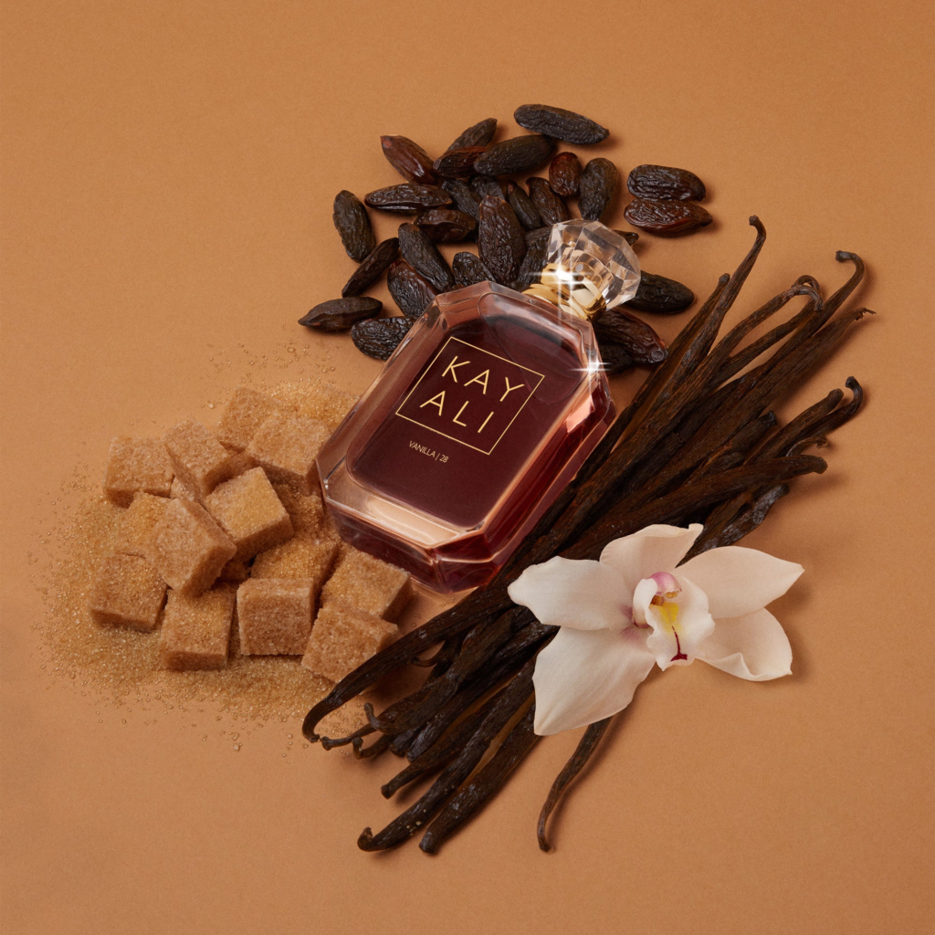 A faceted, jewel-like glass bottle of Kayali Vanilla 28 featuring a crystalline cap and dark amber-colored liquid, highlighting its warm, gourmand scent profile.