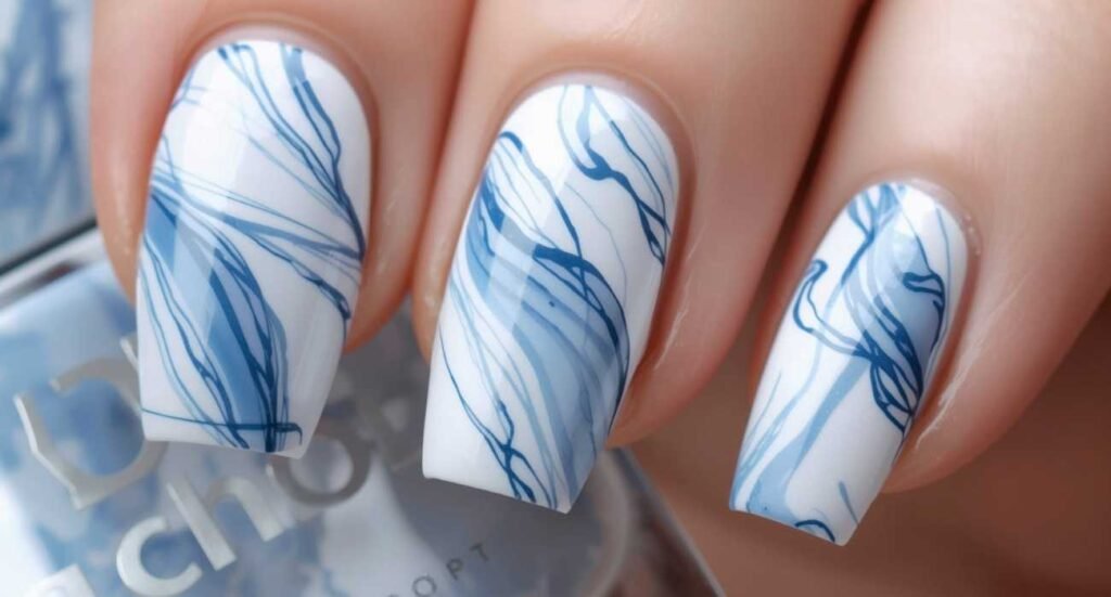 Intricate blue alcohol ink marble design over a solid white almond nail base